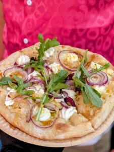Pizza met rucola en rode ui